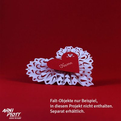 Weißes Falt-Herz mit rotem Namensschild auf rotem Hintergrund mit dem Logo von ARNi-Plott.