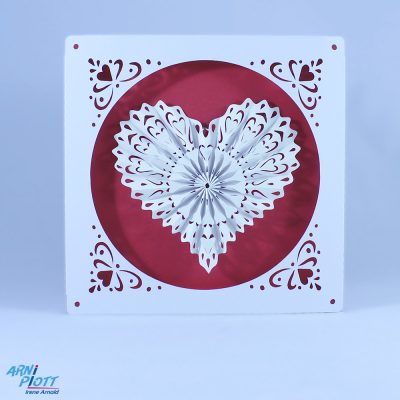 Plottervorlage für eine besondere Hochzeitskarte - hier in Rot-Weiß. Das bezaubernde filigrane Herz kann einfach entnommen werden. Die Hülle ist mit mit Herzen verziert. Abbildung auf hellblauem Hintergrund mit dem Logo von ARNi-Plott.